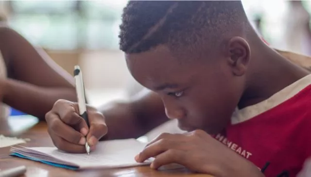 A boy and girl writing at school