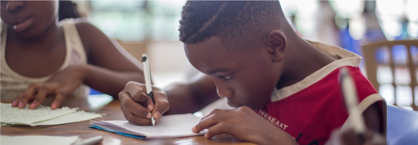 A boy and girl writing at school