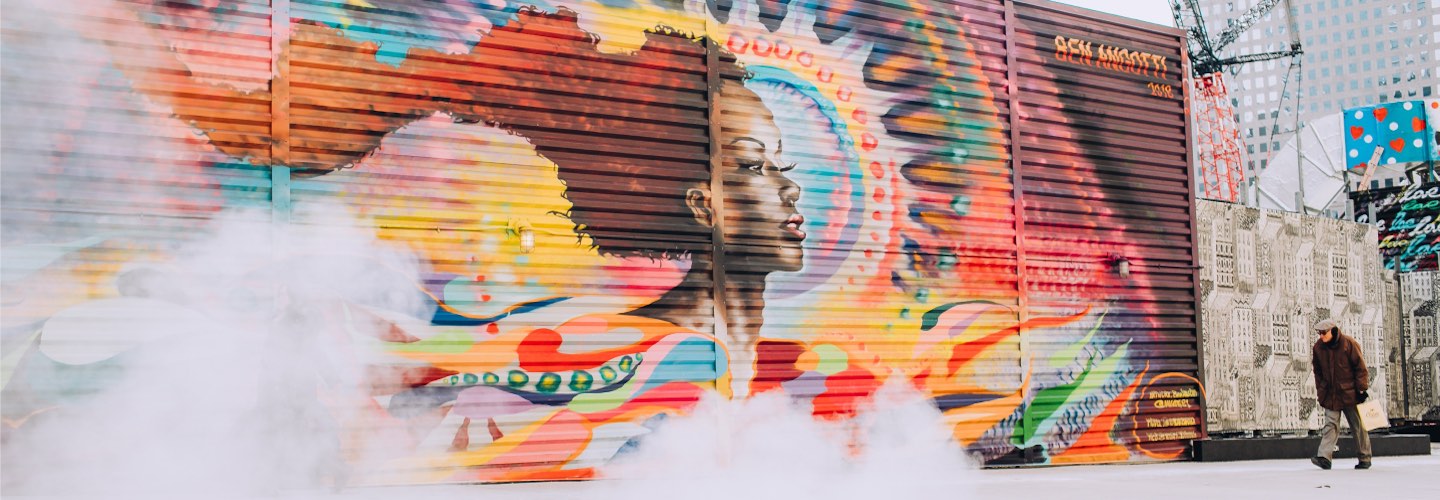 Person walking in front of a mural