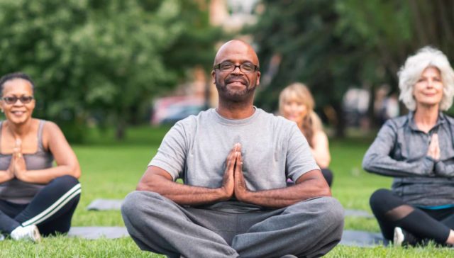 community wellness program with people meditating in the park