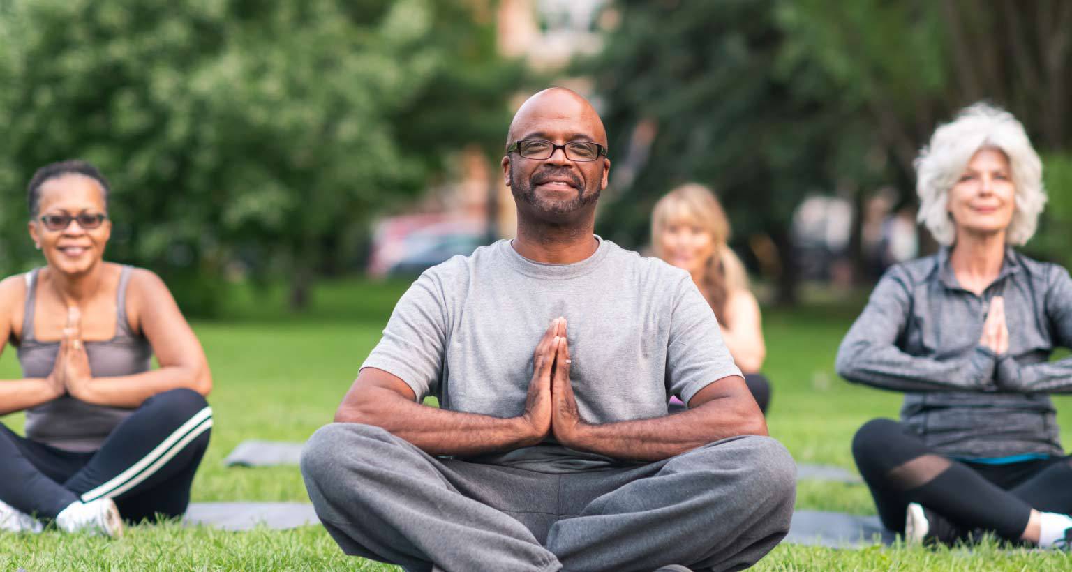 community wellness program with people meditating in the park