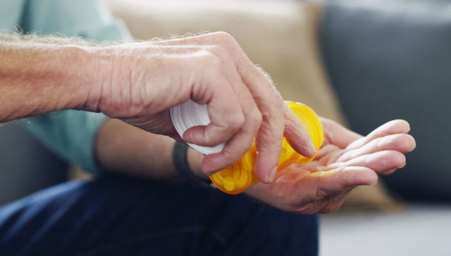 hands holding a pill bottle substance use disorder